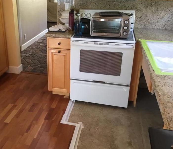 Oven pushed back to wall with tape on floor present