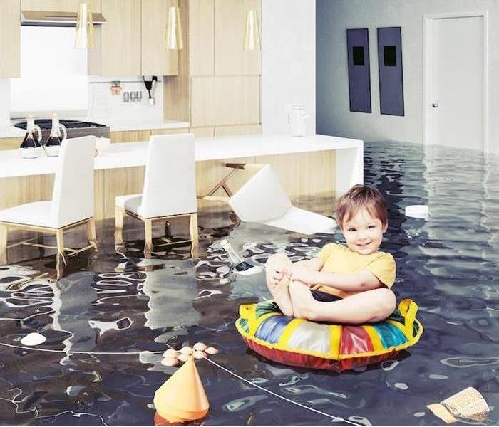 a child floating on an innertube in the kitchen with a flood 